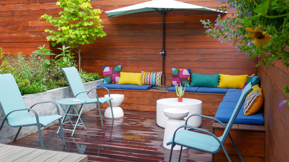 Photo of a small contemporary backyard full sun garden in New York with with privacy feature and decking.