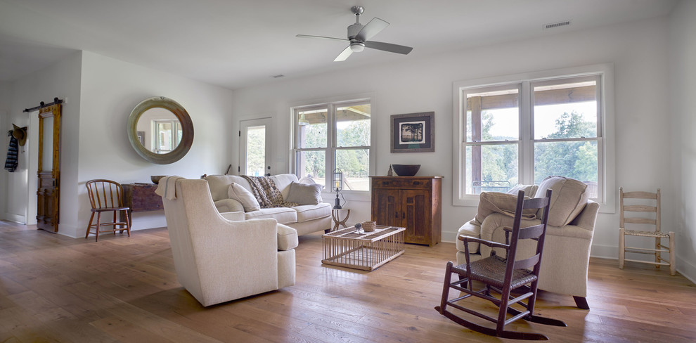 This is an example of a mid-sized country open concept living room in Other with light hardwood floors.