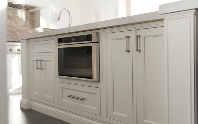 Inspiration for a transitional porcelain tile and gray floor eat-in kitchen remodel in Toronto with an undermount sink, beaded inset cabinets, white cabinets, quartzite countertops, brick backsplash, stainless steel appliances, an island and white countertops