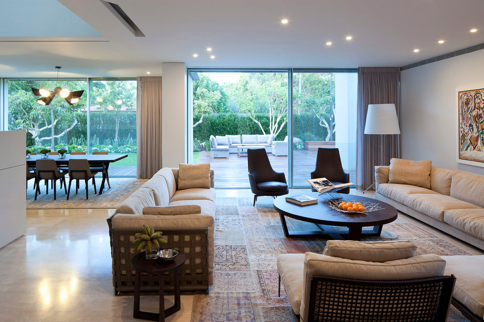 This is an example of a contemporary living room in Tel Aviv with white walls and concrete floors.