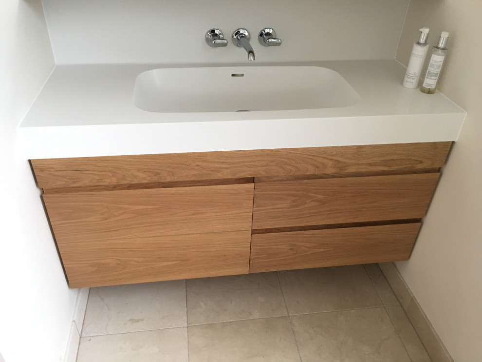 Large contemporary master bathroom in London with flat-panel cabinets and limestone floors.