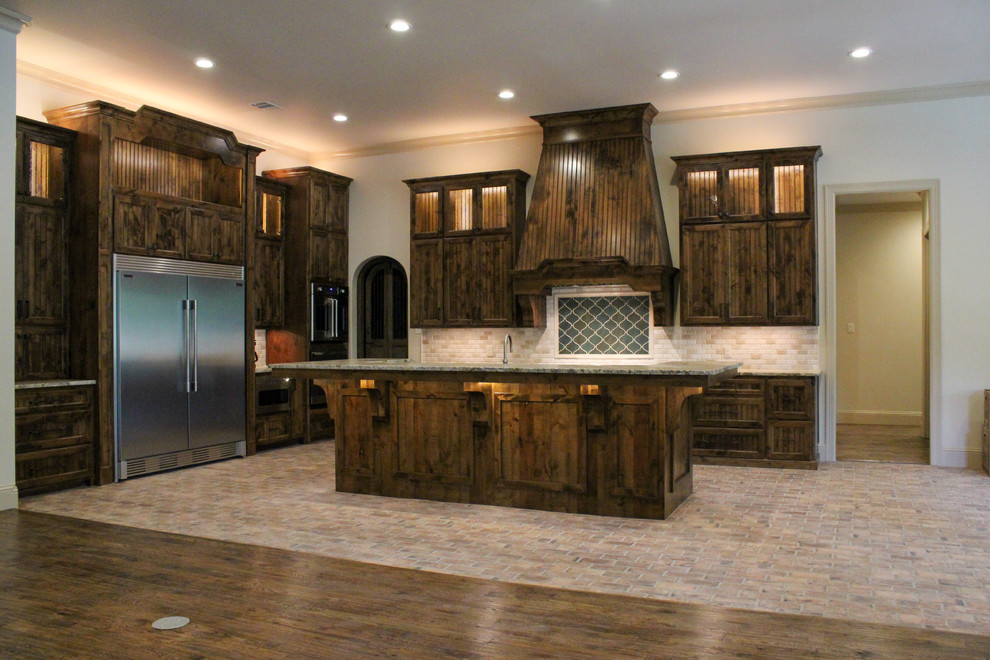 This is an example of a large traditional u-shaped open plan kitchen in Dallas with a drop-in sink, shaker cabinets, medium wood cabinets, granite benchtops, multi-coloured splashback, stone tile splashback, stainless steel appliances, porcelain floors, with island, multi-coloured floor and green benchtop.
