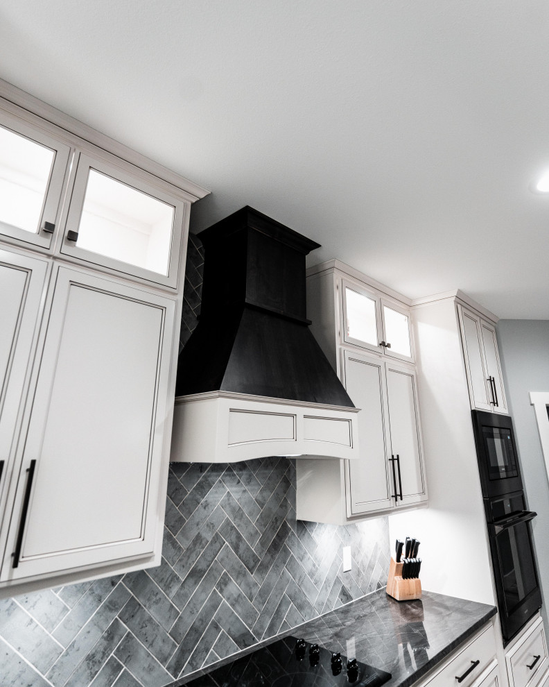Inspiration for a huge transitional l-shaped laminate floor, gray floor and tray ceiling open concept kitchen remodel with an undermount sink, flat-panel cabinets, white cabinets, quartz countertops, gray backsplash, ceramic backsplash, black appliances and an island