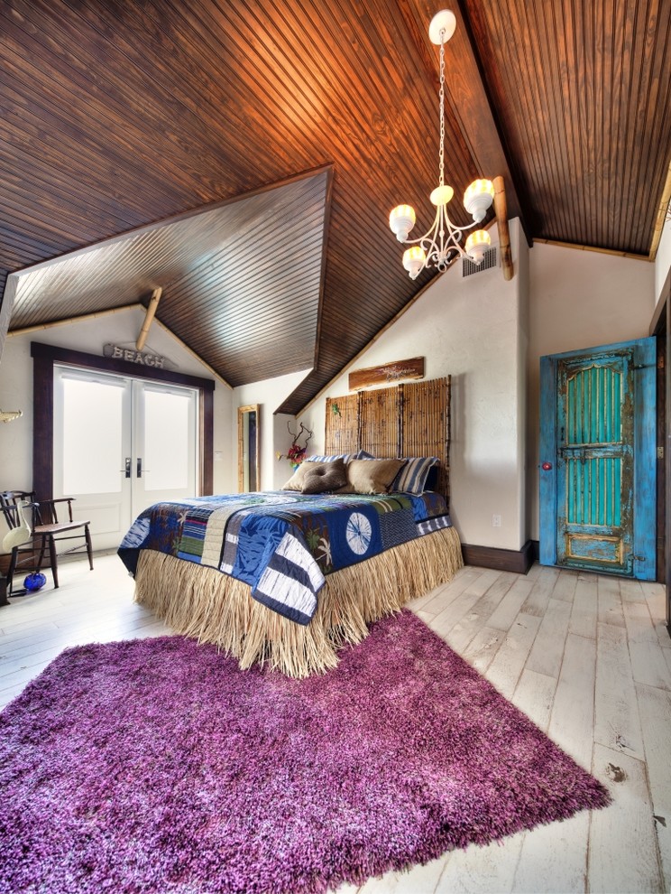 This is an example of an eclectic bedroom in Tampa with beige walls and light hardwood floors.