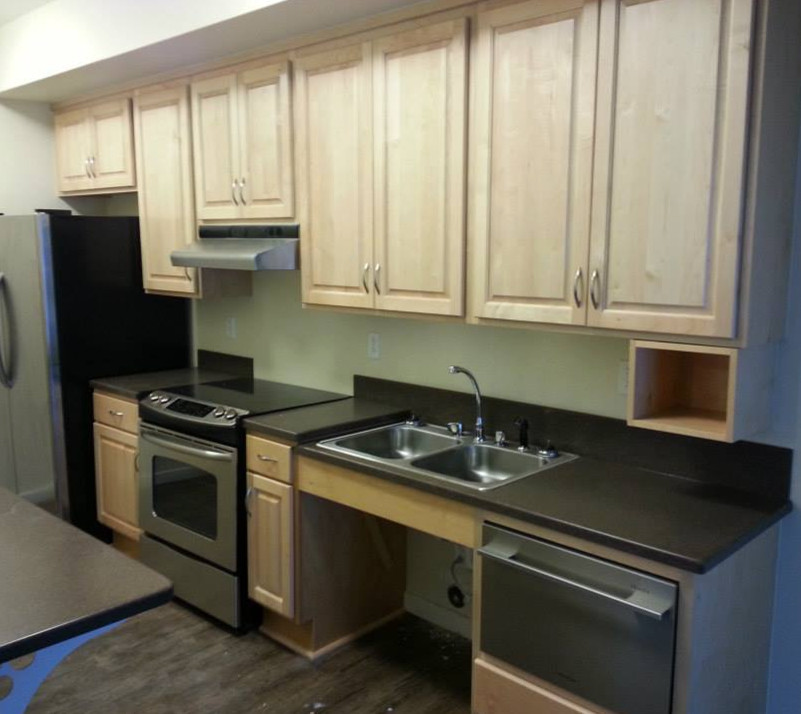 Eat-in kitchen - u-shaped dark wood floor eat-in kitchen idea with a drop-in sink, raised-panel cabinets, light wood cabinets, laminate countertops and stainless steel appliances