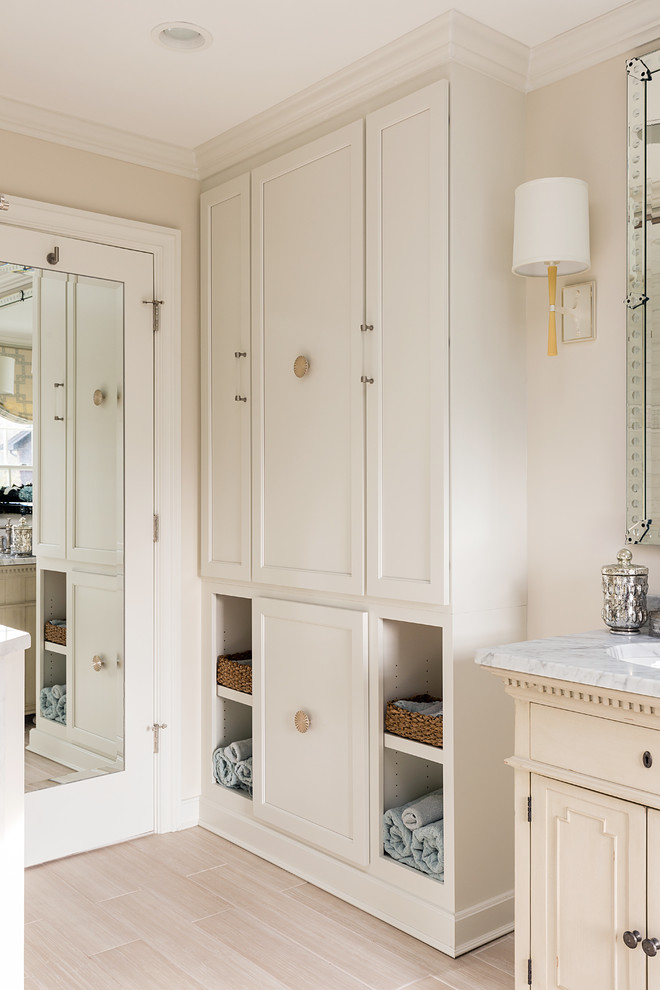 This is an example of a mid-sized traditional master bathroom in Boston with furniture-like cabinets, beige cabinets, a drop-in tub, a corner shower, a one-piece toilet, white tile, beige walls, light hardwood floors and an undermount sink.