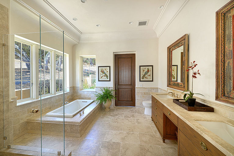 This is an example of a master bathroom in Other with an undermount sink, medium wood cabinets, limestone benchtops, an open shower, beige tile, cement tile and beige walls.