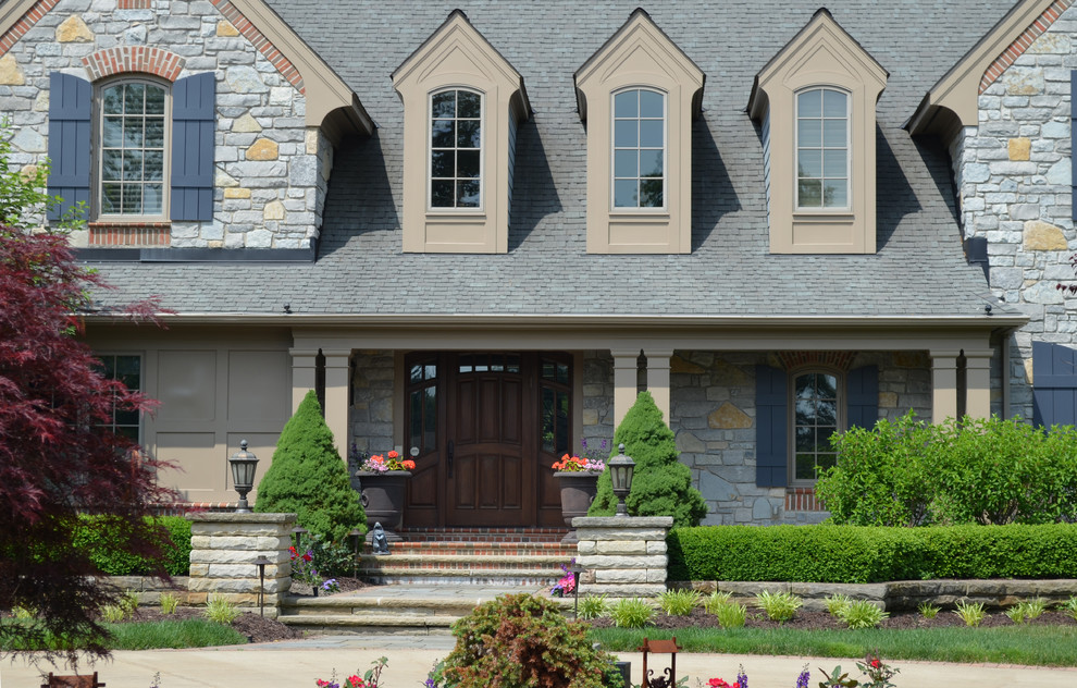 Large arts and crafts two-storey grey exterior in Cleveland with stone veneer.