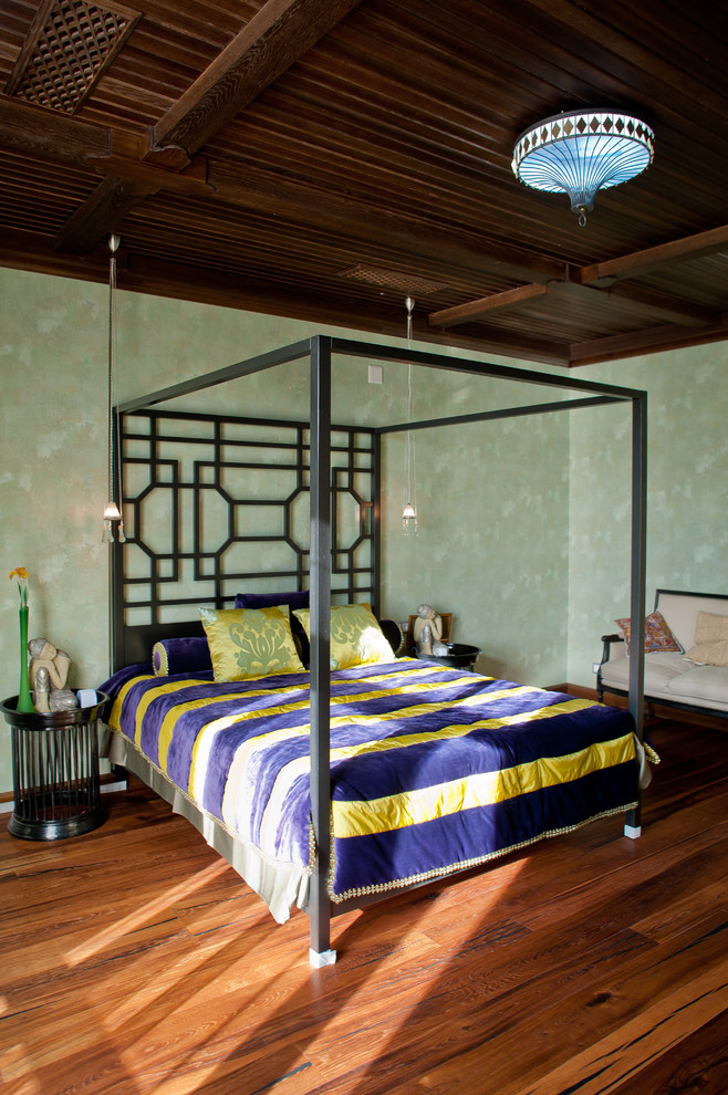 Traditional master bedroom in Other with green walls, medium hardwood floors and brown floor.