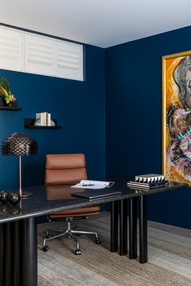 Foto på ett funkis arbetsrum, med blå väggar och ett fristående skrivbord