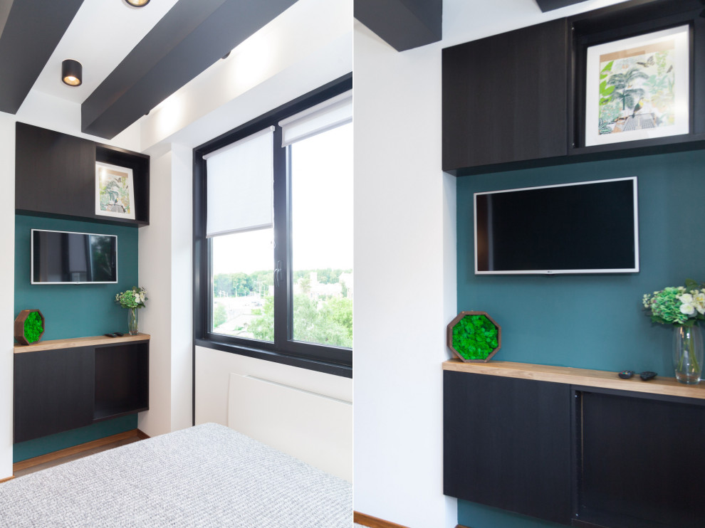 Ejemplo de habitación de invitados contemporánea pequeña con paredes verdes, suelo laminado, suelo marrón y vigas vistas