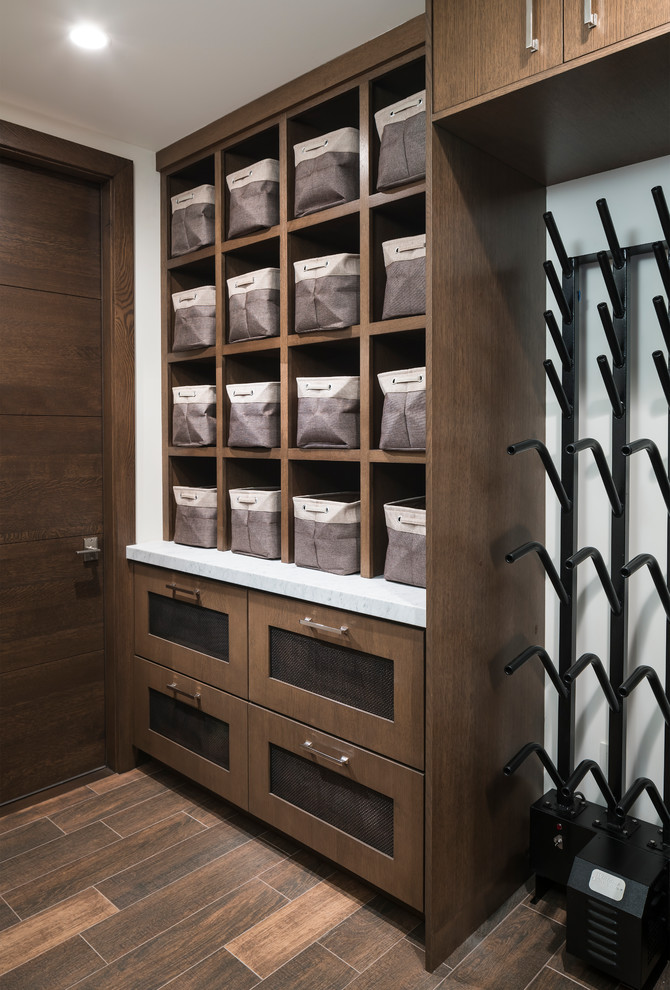 Photo of a contemporary storage and wardrobe in Other with medium wood cabinets and brown floor.