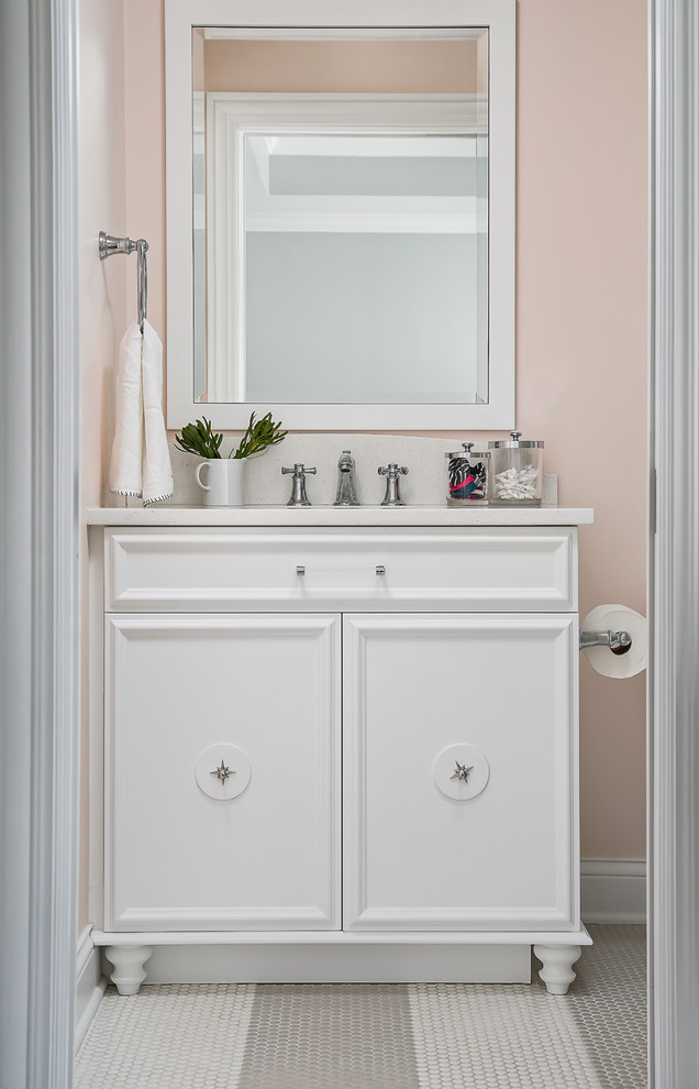 Design ideas for a mid-sized transitional bathroom in Chicago with furniture-like cabinets, white cabinets, a two-piece toilet, pink walls, medium hardwood floors, an undermount sink, engineered quartz benchtops and brown floor.