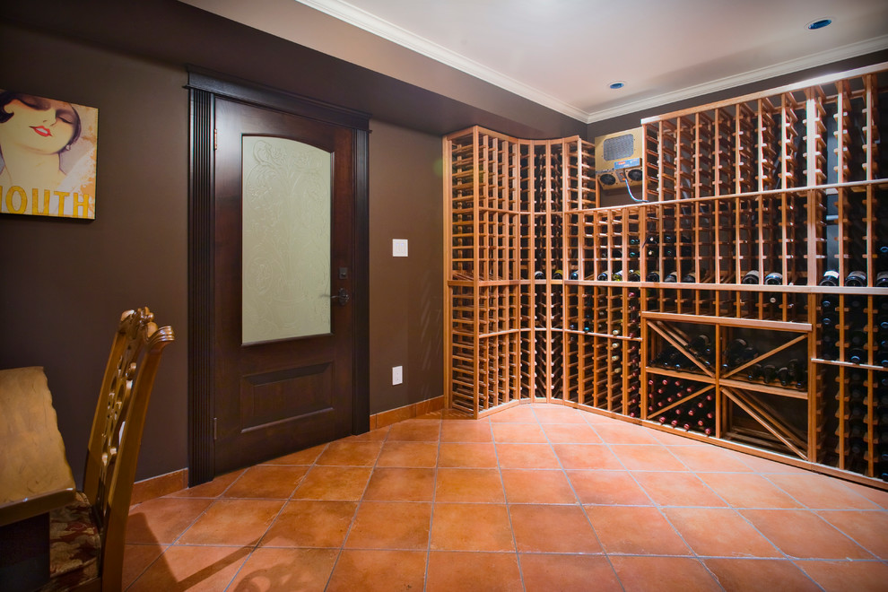 Photo of a large transitional wine cellar in Vancouver with terra-cotta floors, storage racks and orange floor.