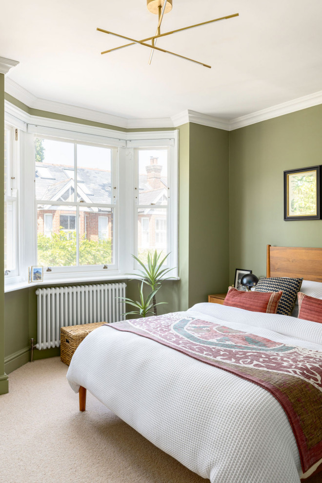 Réalisation d'une grande chambre tradition avec un mur vert et un sol beige.