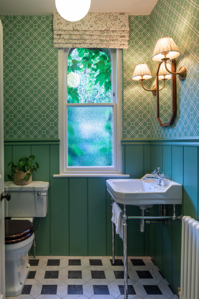 Klassische Gästetoilette mit grüner Wandfarbe, Waschtischkonsole, buntem Boden, vertäfelten Wänden und Tapetenwänden in Cheshire