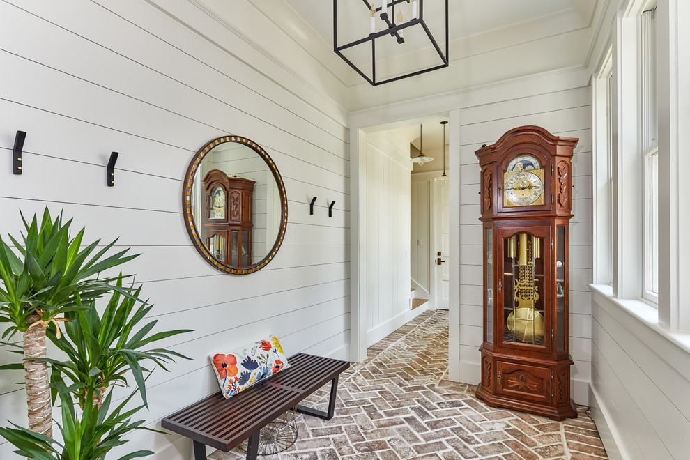 Design ideas for a large beach style hallway in Charleston with white walls and brick floors.