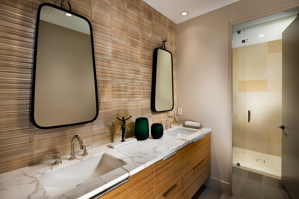Design ideas for a large contemporary master bathroom in Phoenix with flat-panel cabinets, medium wood cabinets, porcelain floors, an undermount sink, engineered quartz benchtops, a hinged shower door, white benchtops, a curbless shower, brown tile, brown walls and black floor.