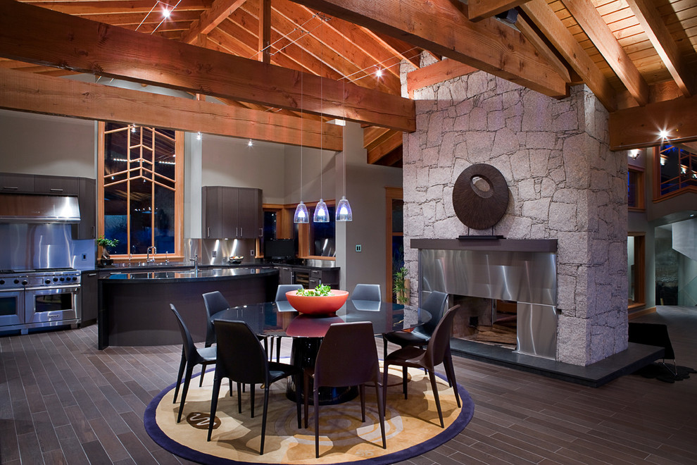 This is an example of a contemporary dining room in Vancouver with a stone fireplace surround.