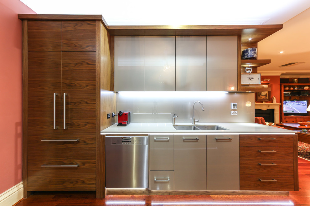 Design ideas for a mid-sized contemporary galley eat-in kitchen in Adelaide with an undermount sink, flat-panel cabinets, medium wood cabinets, quartz benchtops, beige splashback, glass sheet splashback, panelled appliances, dark hardwood floors and no island.