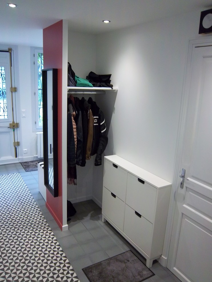 This is an example of a mid-sized traditional foyer in Paris with white walls, ceramic floors, a single front door, a gray front door and grey floor.