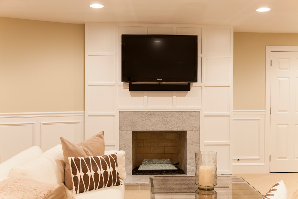 This is an example of a large traditional fully buried basement in Philadelphia with beige walls, carpet, a standard fireplace and a stone fireplace surround.