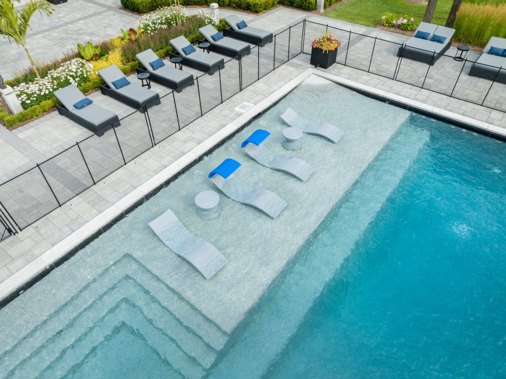 Photo of an expansive transitional backyard rectangular pool in Toronto with with a pool and concrete pavers.