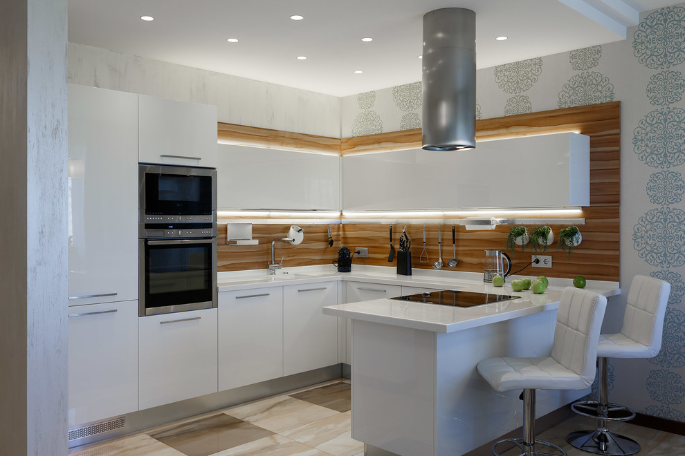 This is an example of a mid-sized contemporary l-shaped open plan kitchen in Saint Petersburg with an integrated sink, flat-panel cabinets, white cabinets, solid surface benchtops, brown splashback, timber splashback, stainless steel appliances, ceramic floors, beige floor and white benchtop.