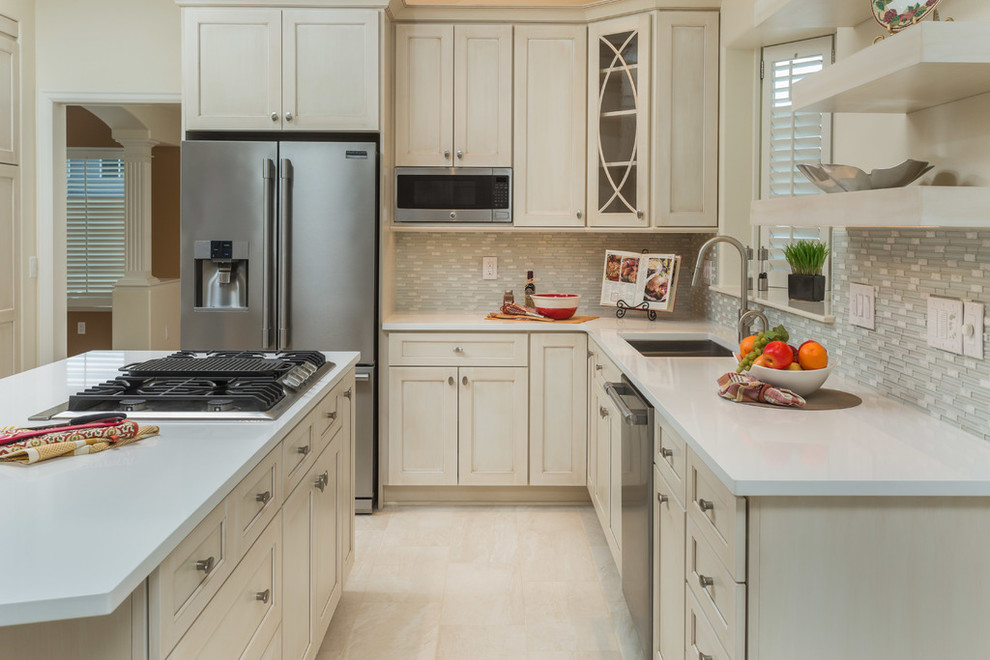 Eat-in kitchen - mid-sized transitional l-shaped eat-in kitchen idea with recessed-panel cabinets, beige cabinets, gray backsplash, stainless steel appliances and an island