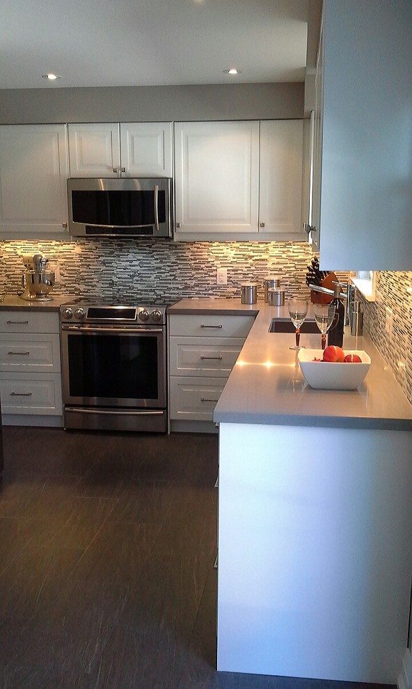 Eat-in kitchen - mid-sized transitional l-shaped porcelain tile eat-in kitchen idea in Toronto with an undermount sink, raised-panel cabinets, white cabinets, quartz countertops, multicolored backsplash, stone tile backsplash and stainless steel appliances