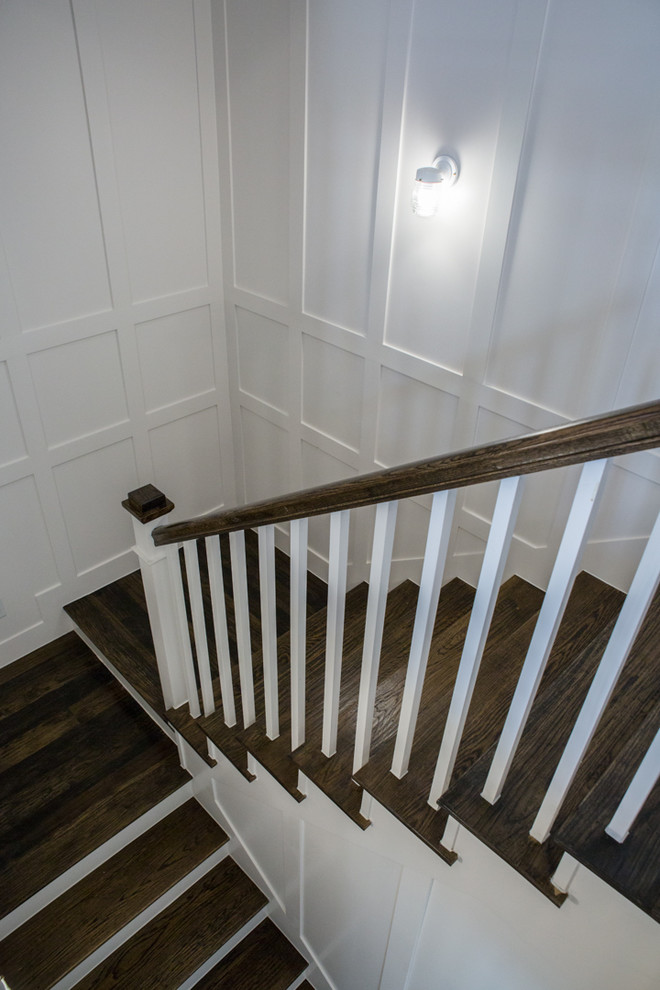 На фото: п-образная лестница среднего размера в стиле кантри с деревянными ступенями, крашенными деревянными подступенками и деревянными перилами