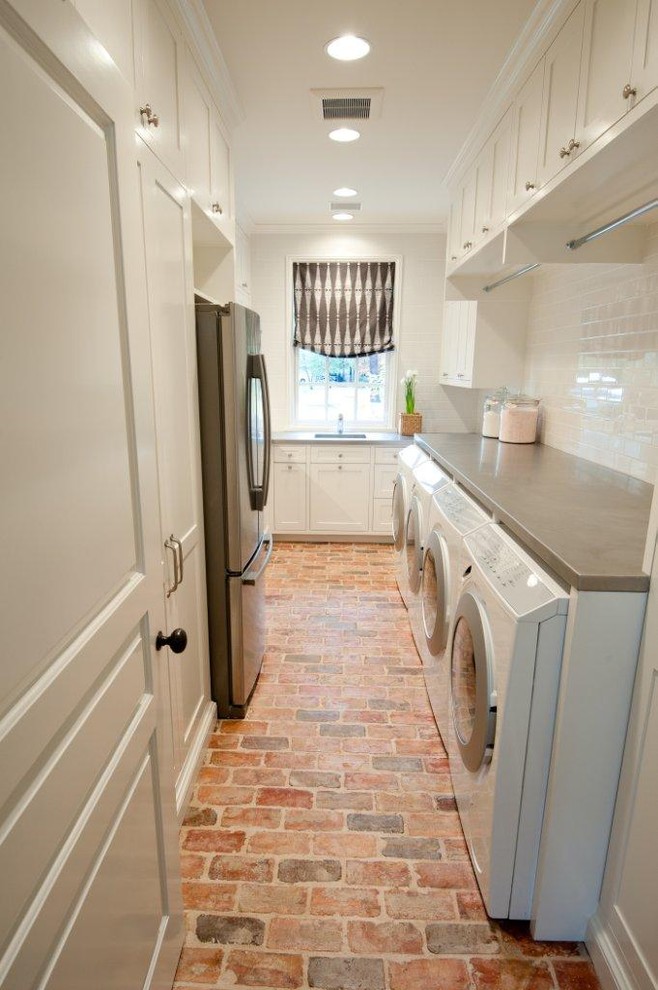 This is an example of a traditional laundry room in Houston with brick floors and red floor.
