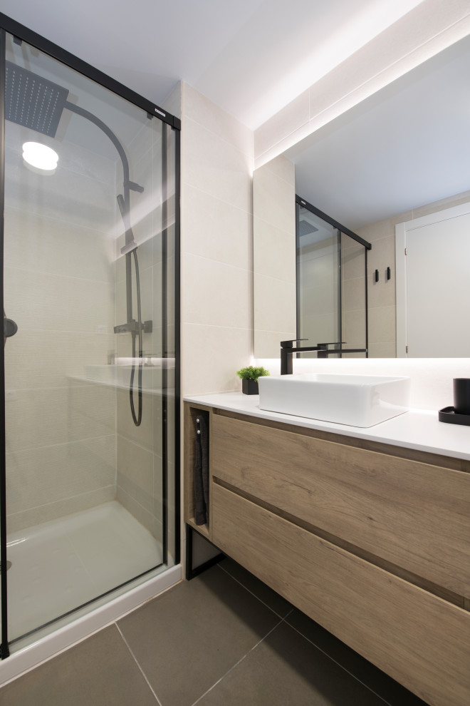 Mid-sized scandinavian 3/4 bathroom in Barcelona with an alcove shower, a vessel sink, a sliding shower screen, flat-panel cabinets, beige cabinets, beige tile, porcelain tile, white walls, porcelain floors, grey floor, white benchtops and a freestanding vanity.