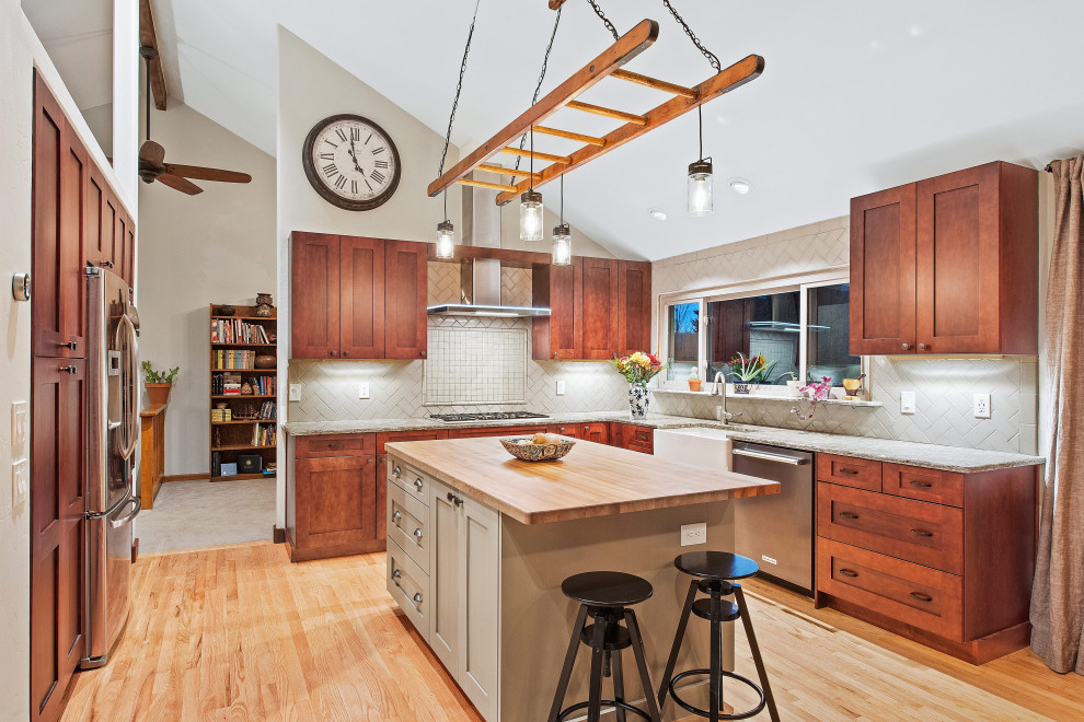 Kitchen - transitional u-shaped light wood floor and beige floor kitchen idea in Denver with a farmhouse sink, shaker cabinets, medium tone wood cabinets, stainless steel appliances, an island and gray countertops