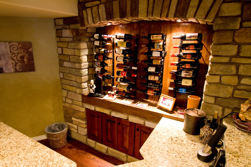 This is an example of a large country wine cellar in Denver with dark hardwood floors and storage racks.