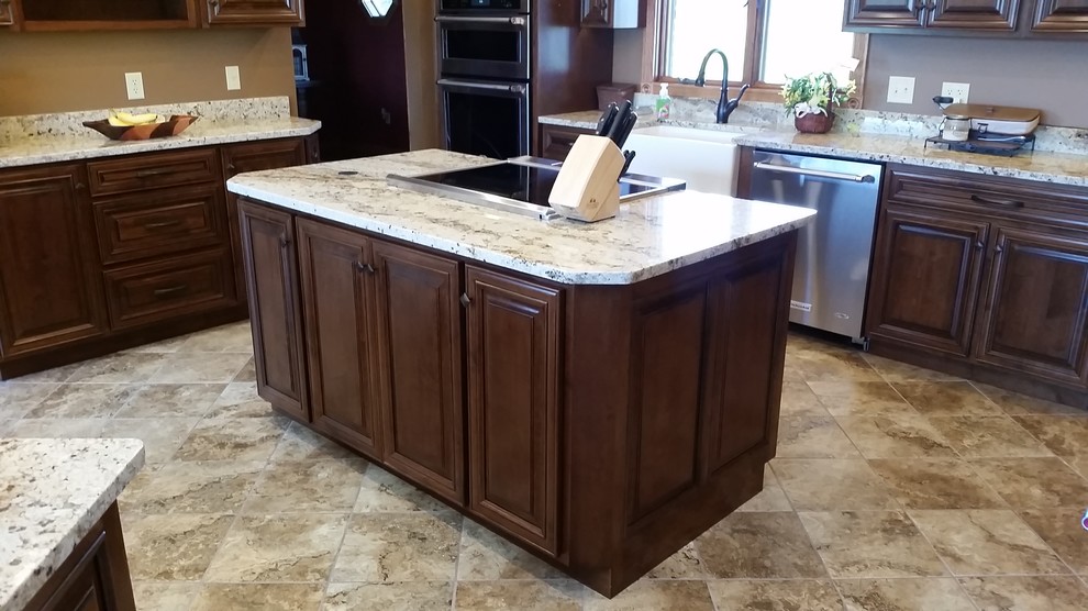 Large elegant u-shaped ceramic tile kitchen photo with a farmhouse sink, raised-panel cabinets, medium tone wood cabinets, granite countertops, stainless steel appliances and two islands