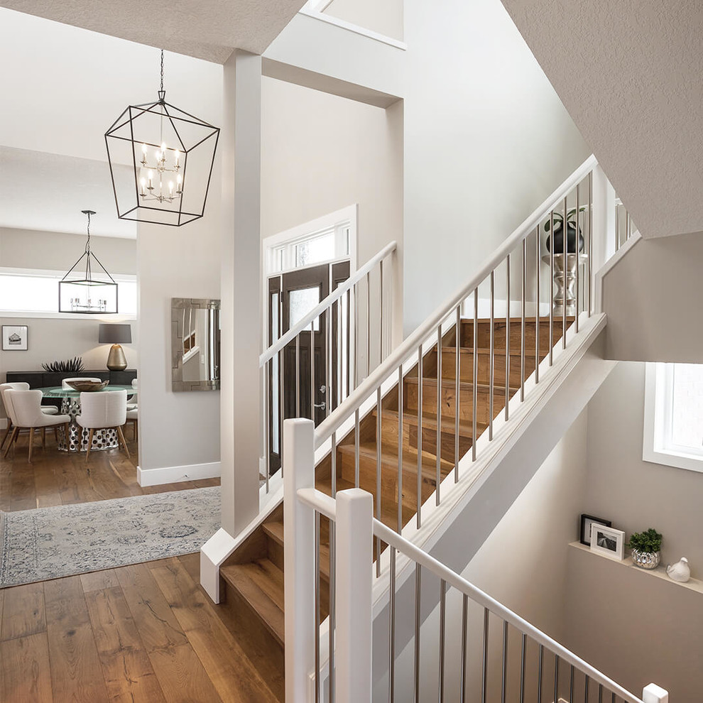 Large transitional entry hall in Calgary with white walls, light hardwood floors, a single front door and a dark wood front door.