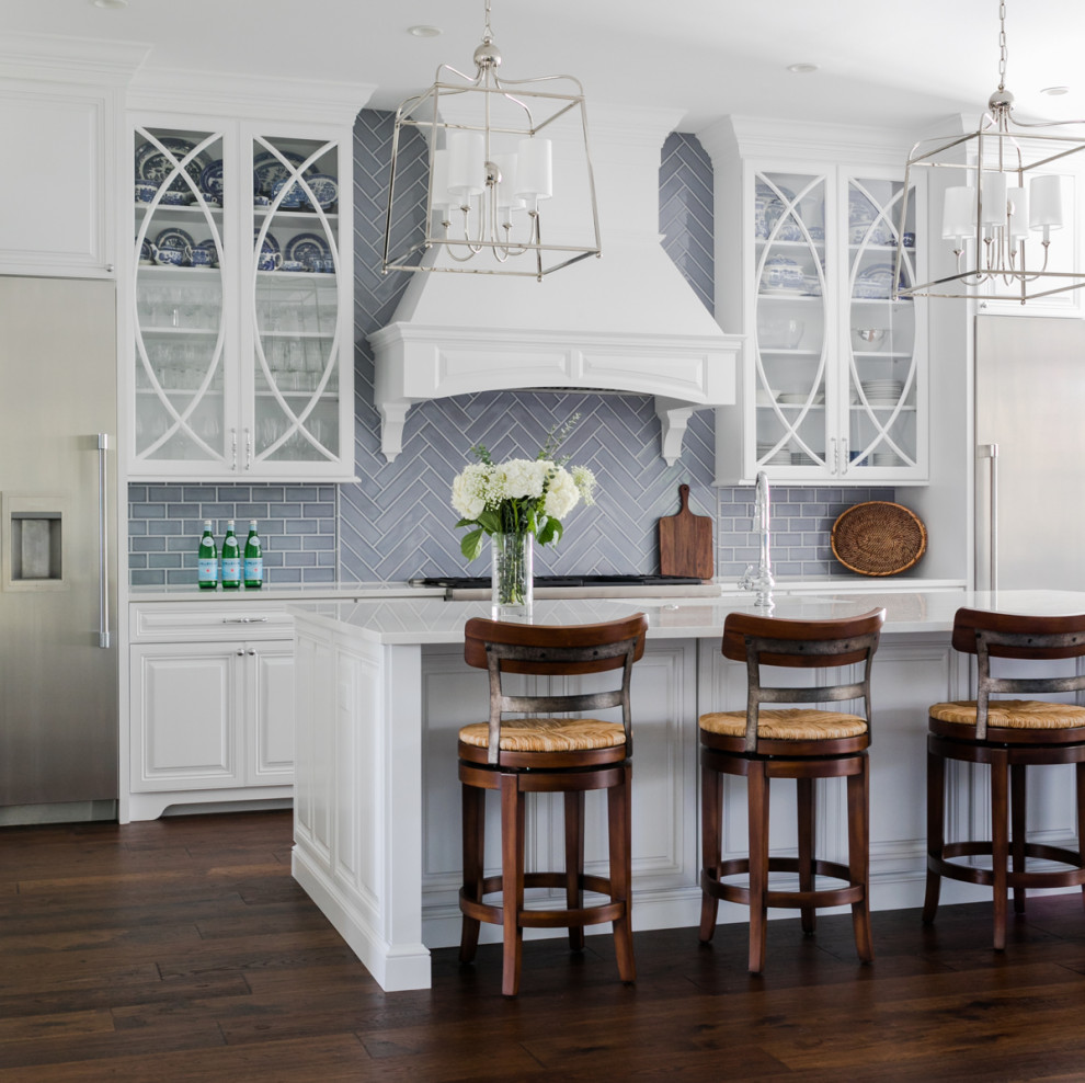 Inspiration for a large beach style galley kitchen in Jacksonville with raised-panel cabinets, white cabinets, grey splashback, dark hardwood floors, with island, brown floor and white benchtop.