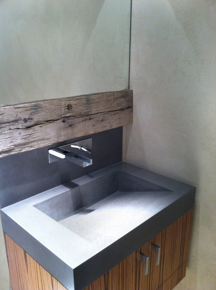 Photo of a mid-sized contemporary 3/4 bathroom in New York with an integrated sink, flat-panel cabinets, medium wood cabinets, concrete benchtops, porcelain tile, beige walls and porcelain floors.