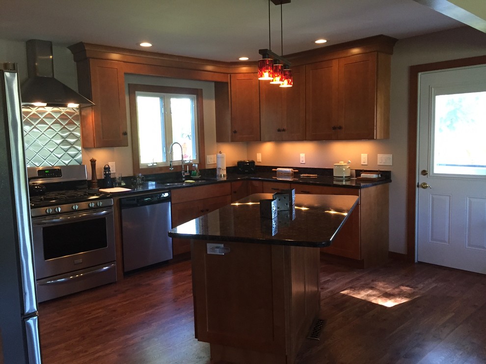 Example of a mid-sized transitional l-shaped medium tone wood floor eat-in kitchen design in Boston with an undermount sink, shaker cabinets, medium tone wood cabinets, granite countertops, beige backsplash, stainless steel appliances and an island