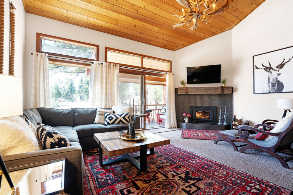 Mid-sized transitional enclosed carpeted, brown floor and vaulted ceiling living room photo in Other with white walls, a corner fireplace, a stone fireplace and a corner tv