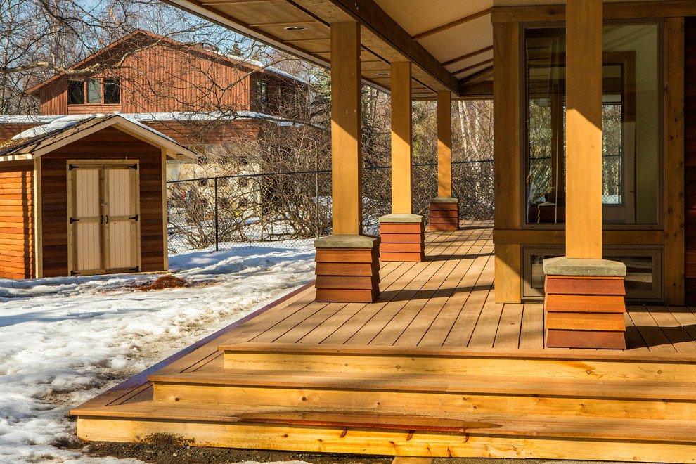 This is an example of a mid-sized arts and crafts backyard deck in Other with a roof extension.
