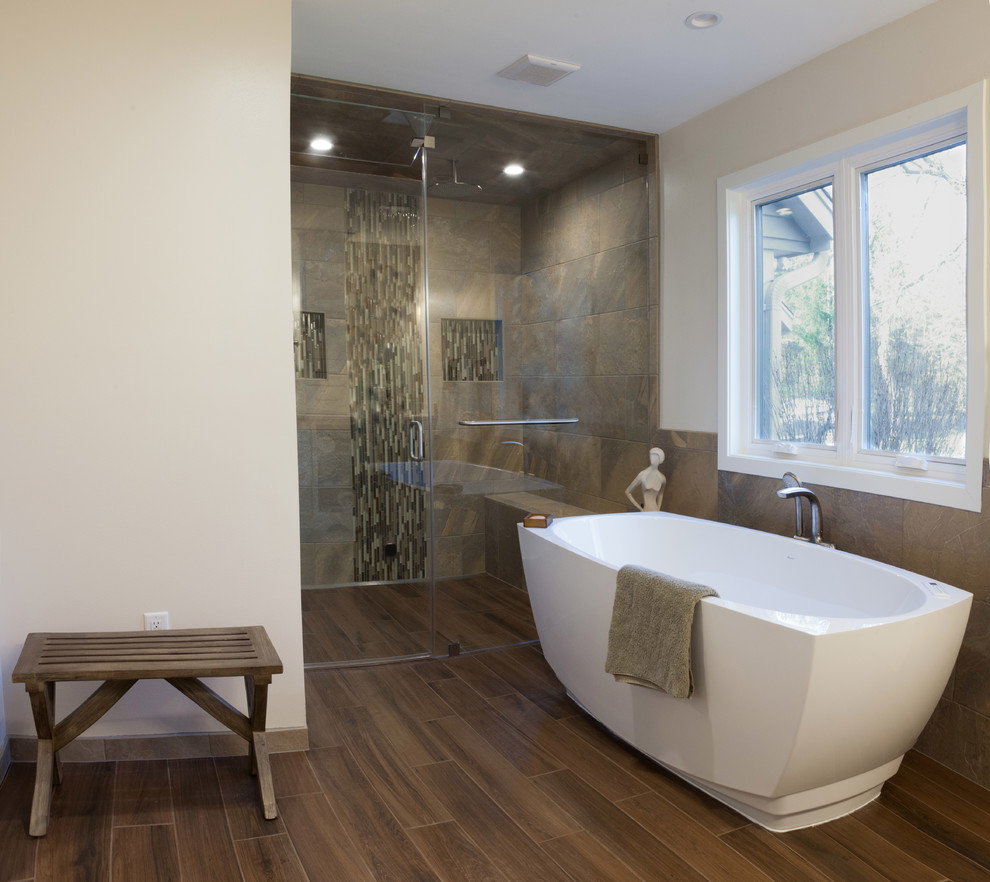 This is an example of a large transitional master bathroom in Milwaukee with a curbless shower, porcelain floors, engineered quartz benchtops, a freestanding tub, a hinged shower door, recessed-panel cabinets, white cabinets, beige tile, brown tile, slate, a two-piece toilet, beige walls, an undermount sink and brown floor.