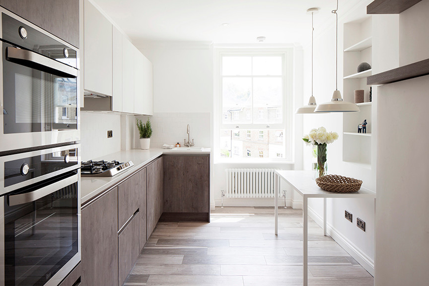 Mid-sized modern kitchen with white splashback, ceramic splashback, light hardwood floors and no island.