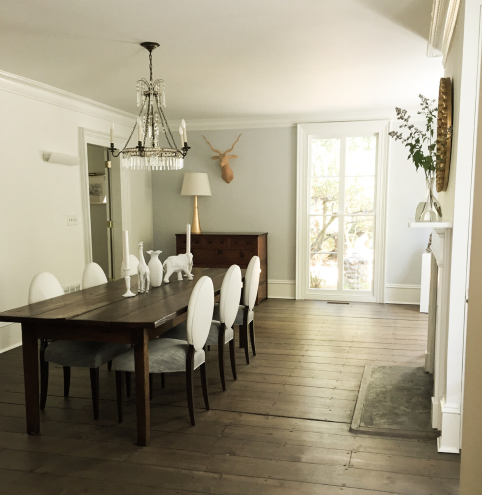 Inspiration for a large transitional separate dining room in New York with white walls, dark hardwood floors, a standard fireplace and a wood fireplace surround.
