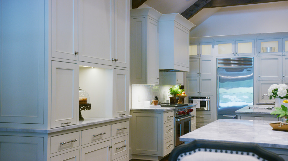 Example of a huge transitional dark wood floor, brown floor and exposed beam eat-in kitchen design with shaker cabinets, beige cabinets, quartzite countertops, beige backsplash, subway tile backsplash, stainless steel appliances, two islands and white countertops