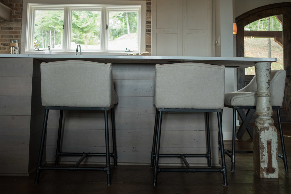 Example of a large transitional galley dark wood floor and brown floor open concept kitchen design with a farmhouse sink, shaker cabinets, quartz countertops, brown backsplash, brick backsplash, stainless steel appliances and an island