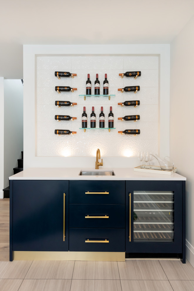 Expansive contemporary single-wall wet bar in Edmonton with no sink, flat-panel cabinets, blue cabinets, black splashback, glass tiled splashback, brown floors and white worktops.
