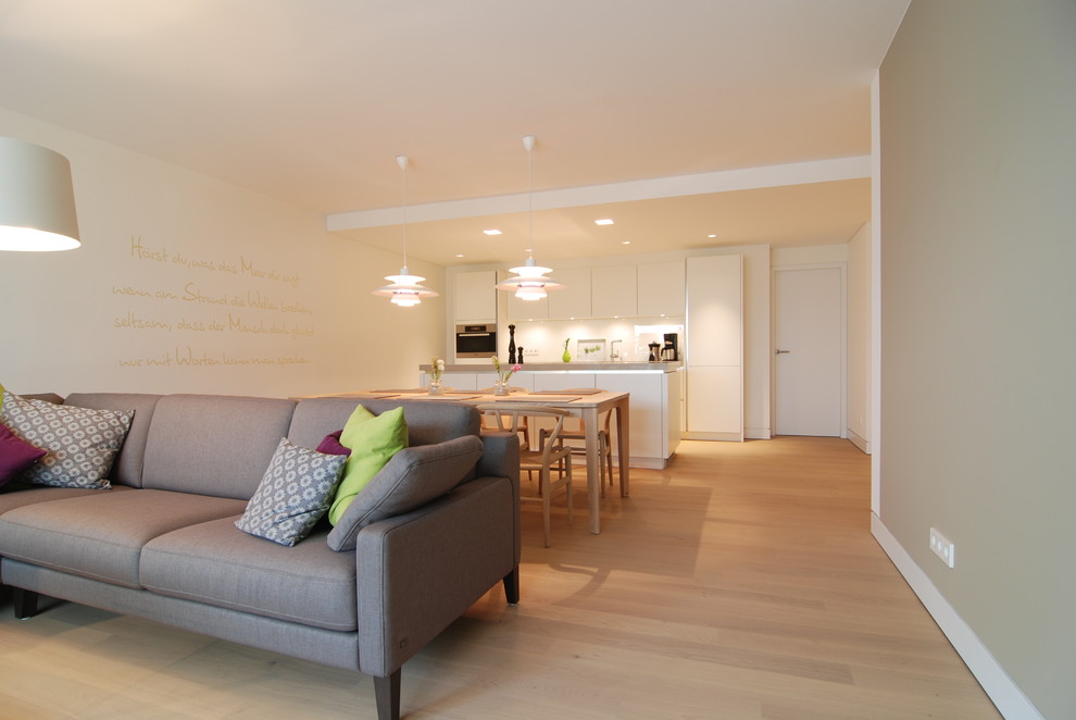 Großes, Fernseherloses, Offenes Modernes Wohnzimmer ohne Kamin mit weißer Wandfarbe, hellem Holzboden und beigem Boden in Hamburg