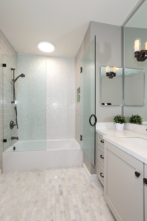 Mid-sized transitional master gray tile porcelain tile and gray floor alcove bathtub photo in Orange County with shaker cabinets, gray cabinets, a one-piece toilet, gray walls, an undermount sink, quartz countertops and a hinged shower door